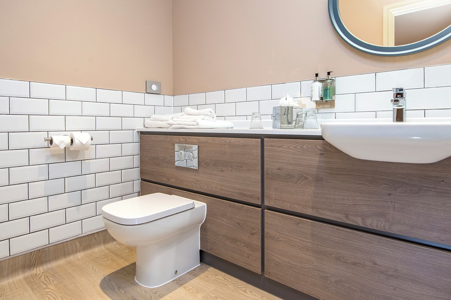 A modern bathroom with a toilet, a sink, and a mirror.
