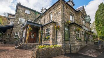 Un edificio de piedra con un cartel que dice "The Swallow Falls Inn".