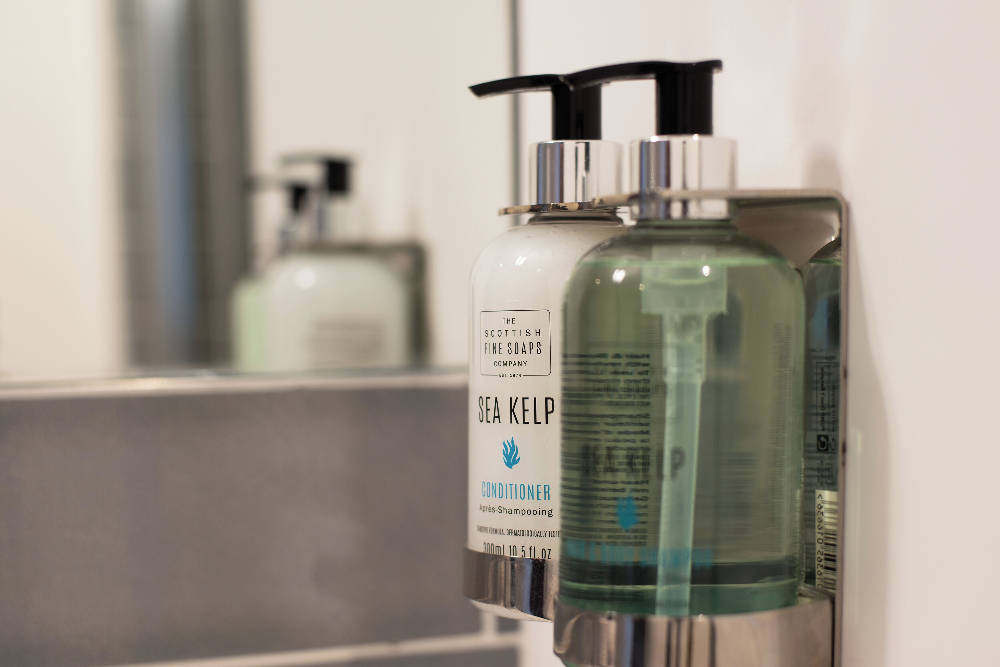 Ein Badezimmer mit einem Waschbecken und zwei Flaschen Sea Kelp Conditioner.