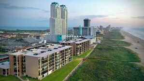 Un hotel moderno de muchas plantas, con vistas a la playa y un área de estacionamiento.