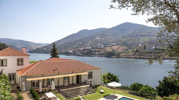 A house with a swimming pool, a patio with outdoor furniture, and a view of a lake and mountains. - Quinta dos Murças (Peso da Régua)