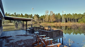 A wooden deck with outdoor seating and a view of a lake.