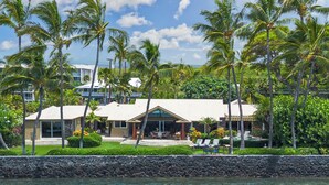 A beachfront property with a pool, palm trees, and a stone wall. - Puako Beach Luxury Oceanfront Home- 3 Guest Suites (Waimea)