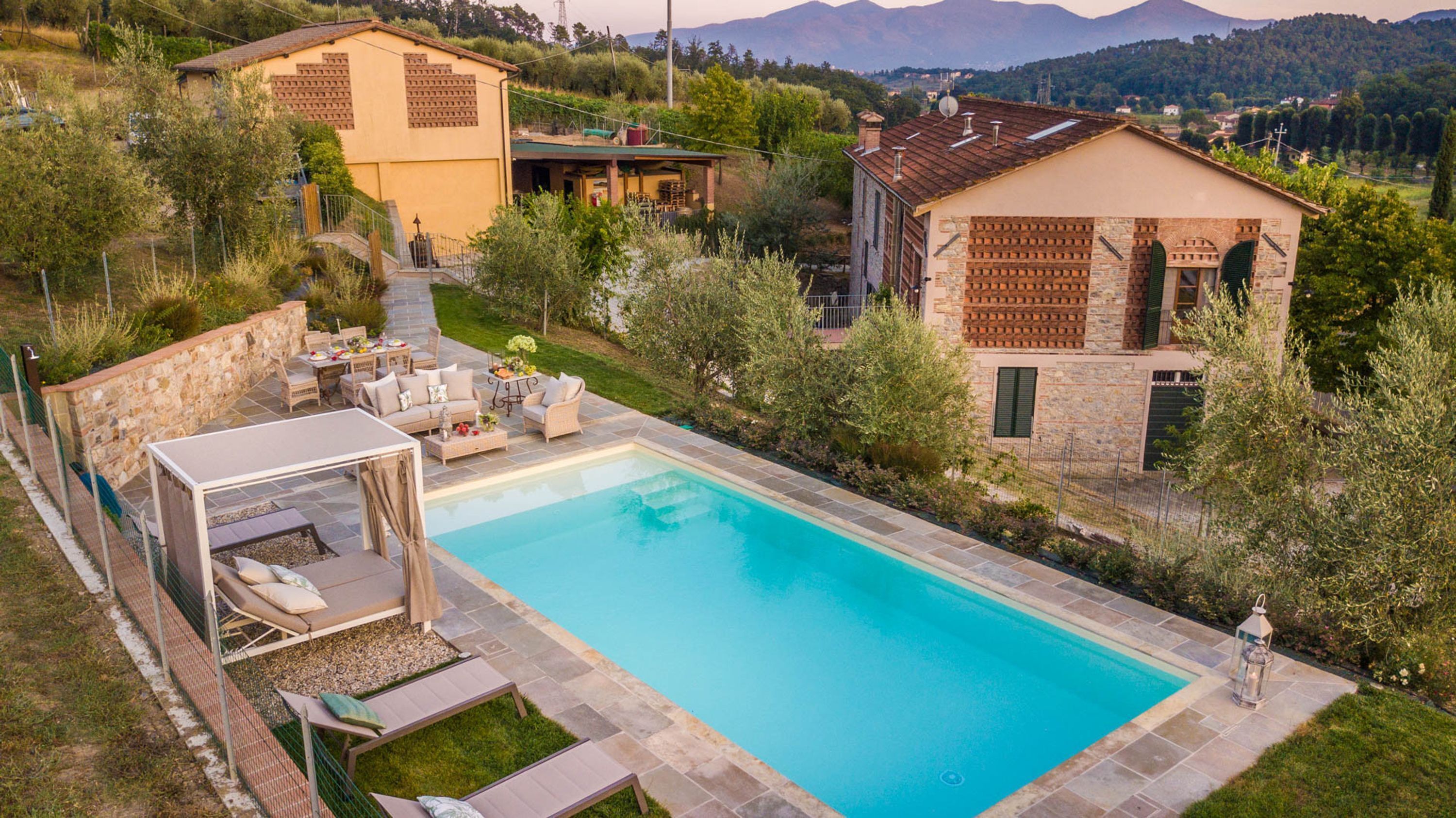 A private pool with outdoor seating and a stone wall.