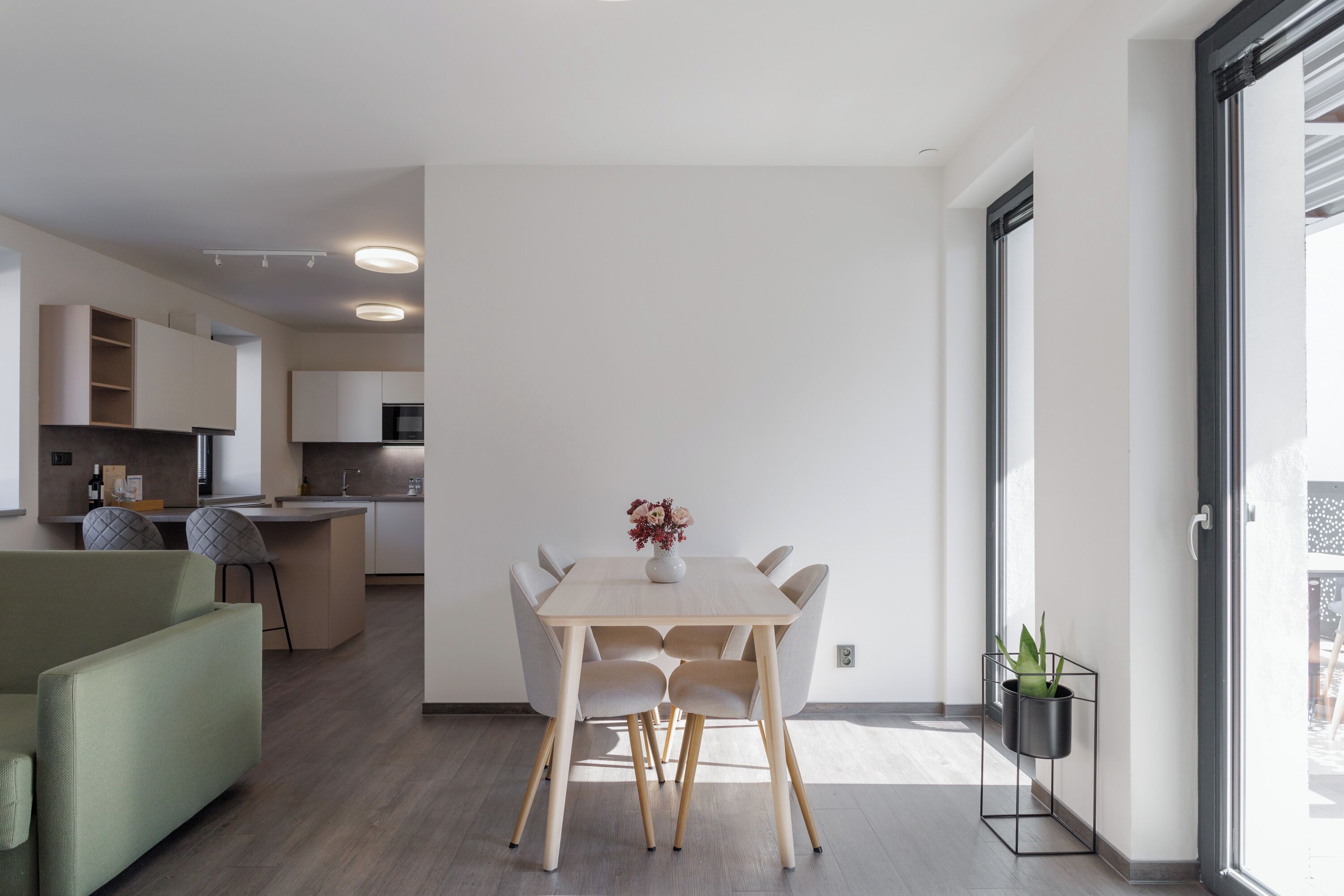 Une cuisine moderne avec un coin repas, comprenant une table et des chaises en bois, un petit îlot central et un four encastré.