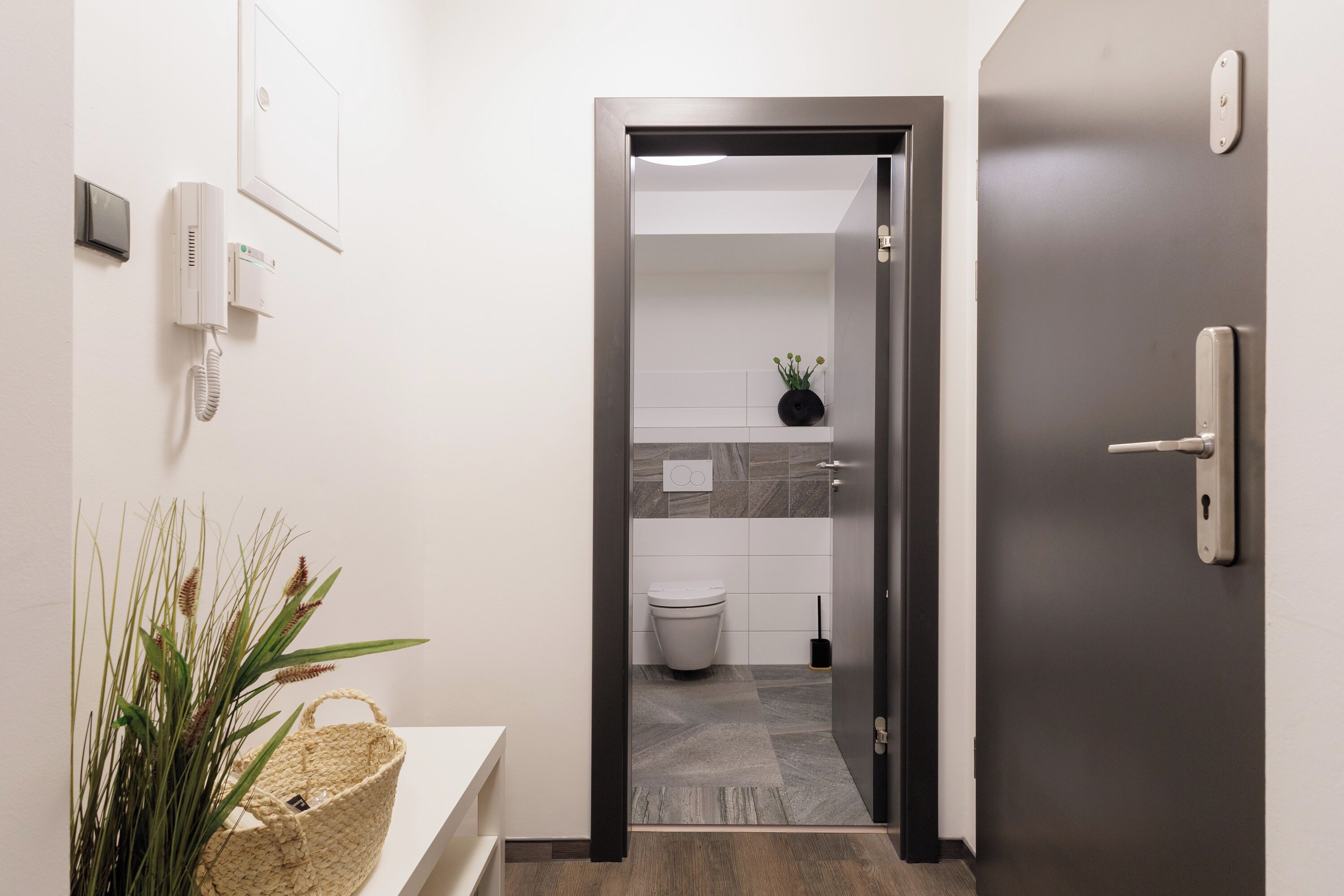 Un baño moderno con inodoro, lavamanos y zona de ducha.