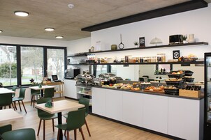 Cocina moderna con un montaje tipo bufé, que incluye diversos alimentos y una estación de café.