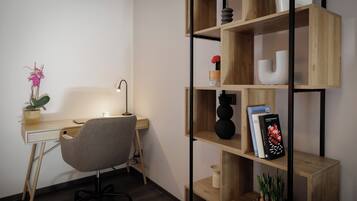 A modern office space with a desk, chair, and a wooden bookshelf with decorative items.