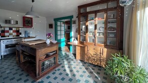 Eine Küche mit einer Holzeile, einem Einbauschrank mit Glastüren und einem Blumentopf.