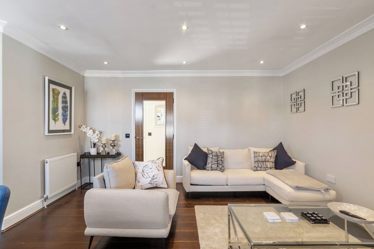 A living room with a sofa, a coffee table, and a radiator.