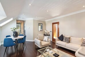 Ein modernes Wohnzimmer mit Essbereich, einer Sofagarnitur und einem Couchtisch.