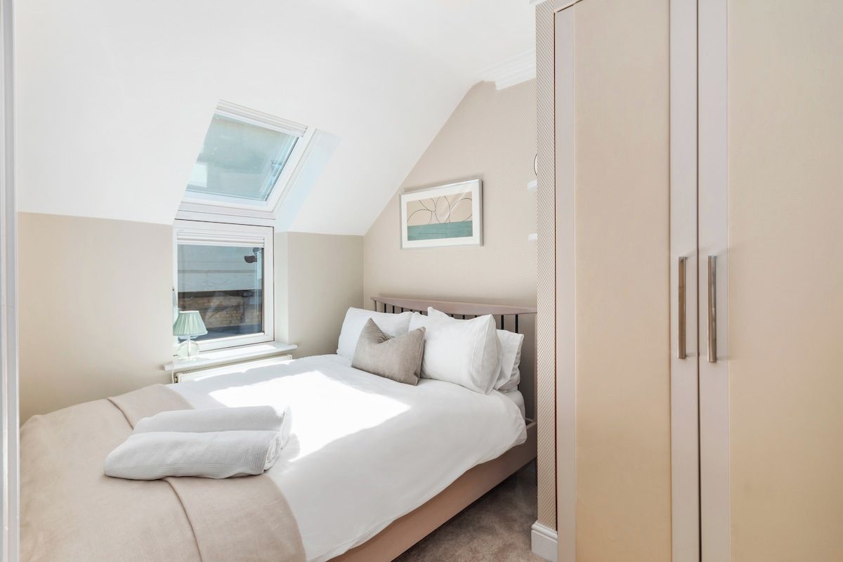 A bedroom with a bed, a window, and a wardrobe.