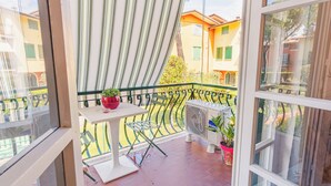 A balcony with a table, a red pot with a plant, and a Haier air conditioner. - Sirmione Studio Apartment (Sirmione)