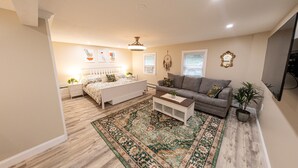 A living room with a bed, a sofa, a coffee table, and a large rug. - Extra large 1 Bedroom apartment! (Salem)
