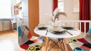 A dining area with a round table, chairs, and a vase of dried flowers. - Huge London 2 Bed Flat w/Parking (Greater London)
