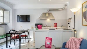 A modern kitchen with a central island, white cabinetry, and a built-in stove. - Giustiniani Loft by Wonderful Italy (Genoa)