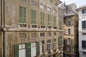 A multi-story building with green shutters, balconies, and ornate architectural details. - Giustiniani Loft by Wonderful Italy (Genoa)