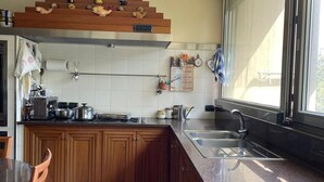 Eine Küche mit Holdekor, einer Arbeitsplatte aus Granit, einem eingebauten Herd und einem Fenster mit Blick.