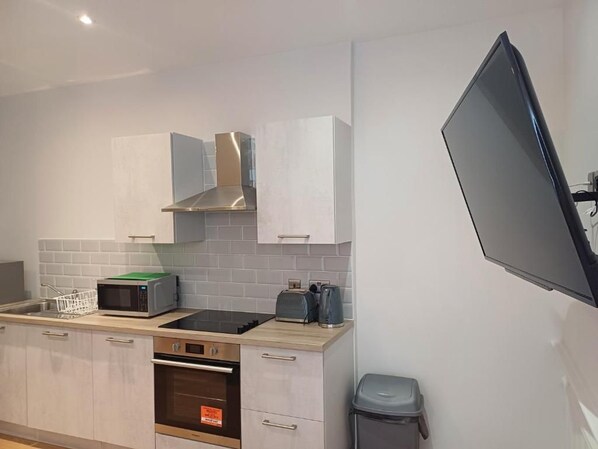 A modern kitchen with a microwave, toaster, and oven. - The Hazlitt Apartments (Paisley)