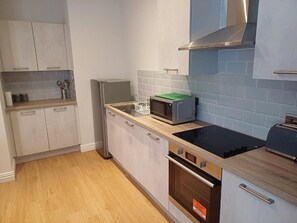 A kitchen with a microwave, oven, and toaster on the counter. - The Hazlitt Apartments (Paisley)