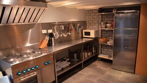 A modern kitchen with stainless steel appliances, a microwave, and a built-in oven. - Domein le Crupet 30 Personen Gelegen op Domein Van3 ha (Hastière)