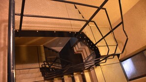 A spiral staircase with metal railings and a textured wall. - Domein le Crupet 30 Personen Gelegen op Domein Van3 ha (Hastière)