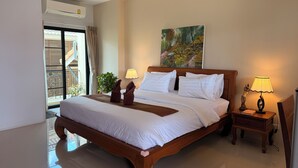 A spacious bedroom with a large bed, two bedside tables, a painting on the wall, and a view of the outside balcony. - Laph Kham House (Chiang Mai)