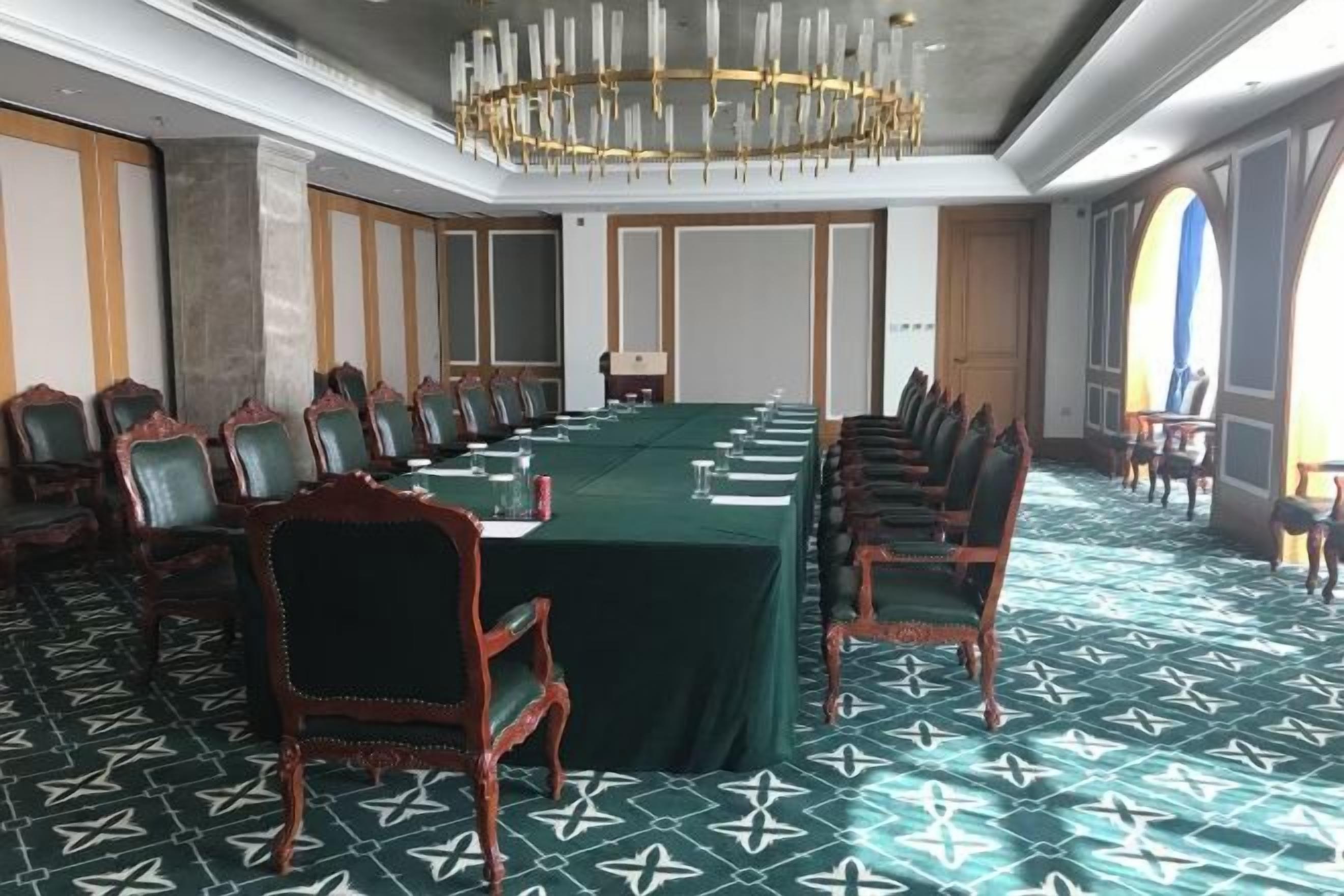 A conference room with a long table, chairs, and a chandelier.