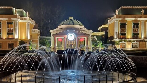 A grand building with a dome and a fountain in front. - Reignwood Pine Valley (Beijing)