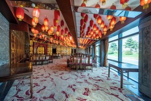 A spacious room with a patterned carpet, traditional lanterns, and large windows. - Reignwood Pine Valley (Beijing)