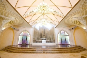 A spacious interior with a high ceiling, a central chandelier, and stained glass windows. - Reignwood Pine Valley (Beijing)