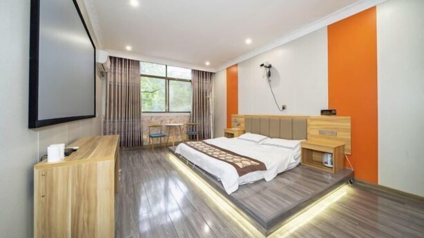 A modern hotel room with a bed, bedside table, and a desk area. - Yanyangtian Business Hotel (Yongzhou)