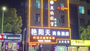 A building with illuminated signs, including one for a business hotel and another for a restaurant. - Yanyangtian Business Hotel (Yongzhou)