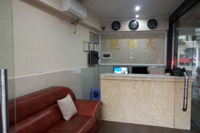 A reception area with a reception desk, a brown leather sofa, and a wall-mounted clock.