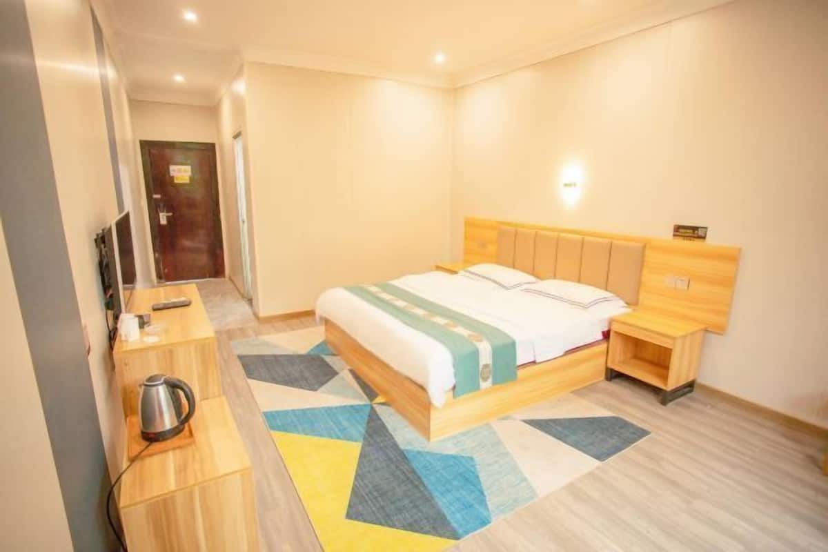 Une chambre d’hôtel avec un lit, une table de chevet et un téléviseur.