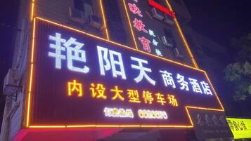 Un letrero de neón con caracteres chinos, que indica un negocio o servicio.