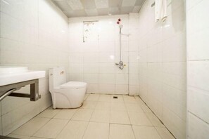 A small, white bathroom with a toilet, a shower, and a sink. - Yanyangtian Business Hotel (Yongzhou)
