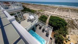 Una piscina en la azotea con vistas a la playa y al océano.