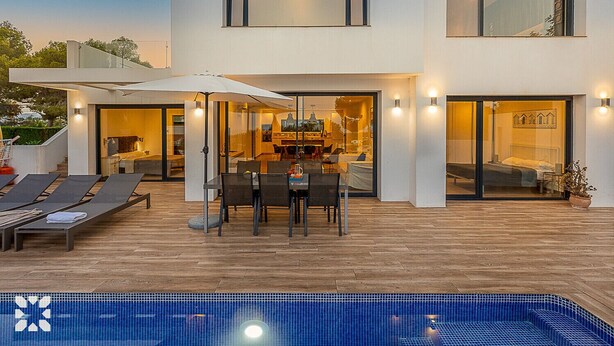 Uma casa moderna de dois andares com piscina, área de estar externa e espaço para refeições.