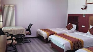 Ein Hotelzimmer mit zwei Betten, einem Schreibtisch und einem Sessel.