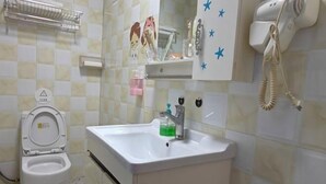 Ein Badezimmer mit Toilette, Waschbecken und einem an der Wand befestigten Föhn.