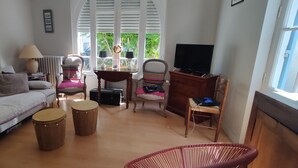 A living room with a sofa, two drums, a television, and a window with blinds. - House with garden near the beach of Arcachon (Arcachon)