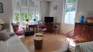 A living room with a sofa, chairs, a television, and a window with blinds. - House with garden near the beach of Arcachon (Arcachon)