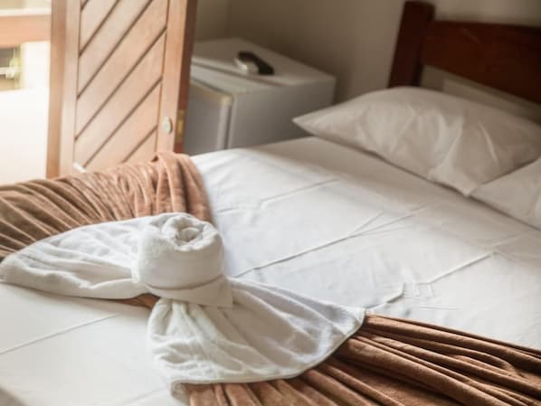 A neatly made bed with white linens and a brown throw blanket. - Hanna Amsterdam Hotel & Eventos (Florianópolis)