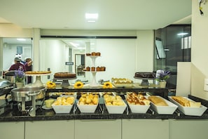 A buffet with various food items and a water dispenser. - Hanna Amsterdam Hotel & Eventos (Florianópolis)