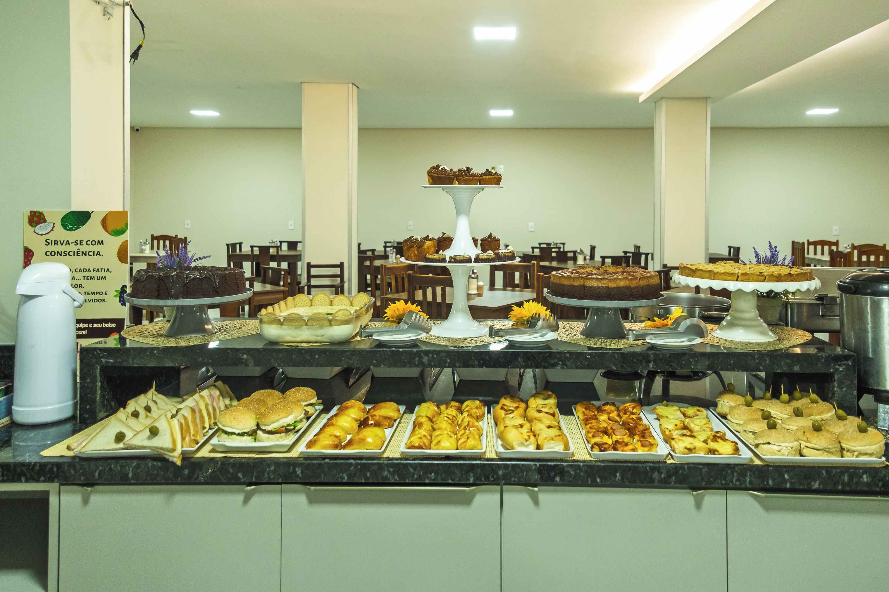 Un bufé con diversos alimentos y un pastel a la vista.