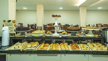 Un bufé con diversos alimentos y un pastel a la vista.