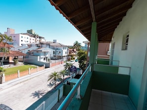 A balcony with a view of a residential area, including houses and a street. - Hanna Amsterdam Hotel & Eventos (Florianópolis)
