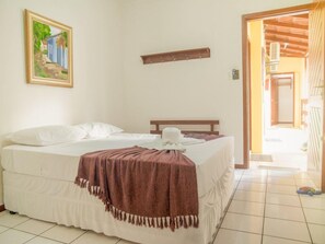 Ein Schlafzimmer mit einem Bett, einem Bild an der Wand und einem Holzregal.