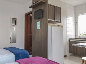 A hotel room with a bed, a small kitchenette, a TV mounted on the wall, and a window. - Hanna Amsterdam Hotel & Eventos (Florianópolis)